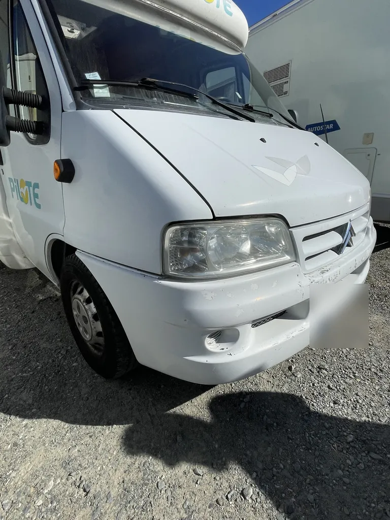 Face avant d'un camping-car, pare-chocs écaillé et rayé