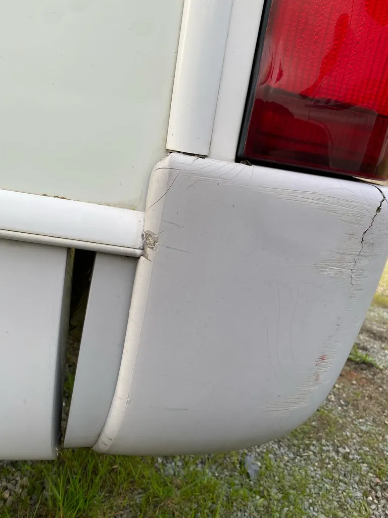 Angle du pare-chocs arrière d'un camping-car, fissuré, près du feu arrière