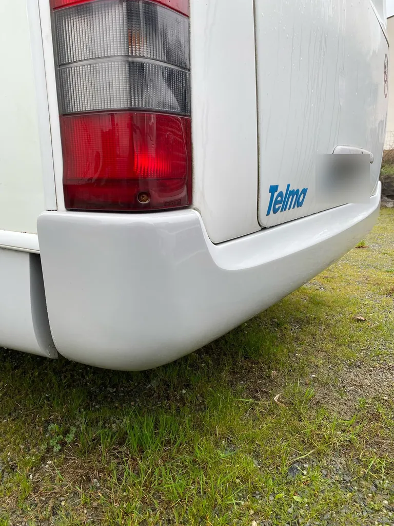 Pare-chocs arrière d'un camping-car, réparé, blanc et lisse, remis en place