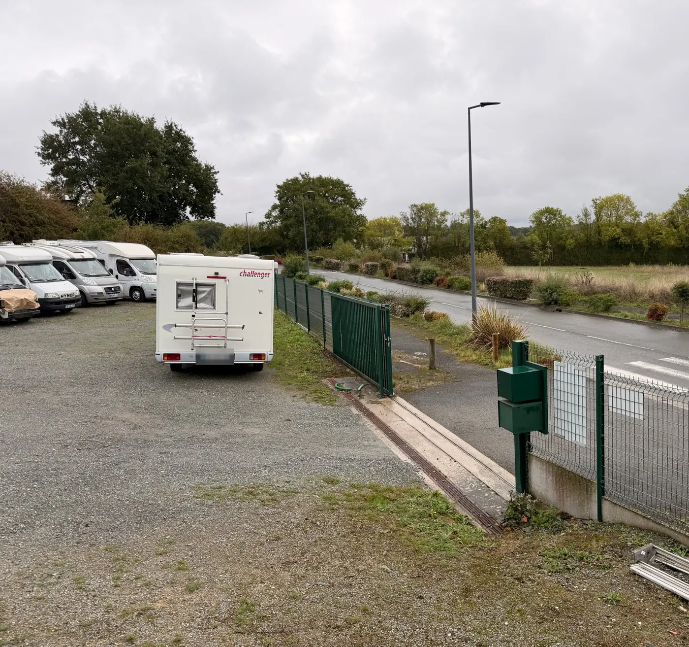 Entrée de l'atelier : portail et parking gravillonné