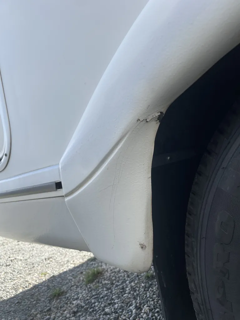 Coin d'un passage de roue de camping-car fissuré et écaillé