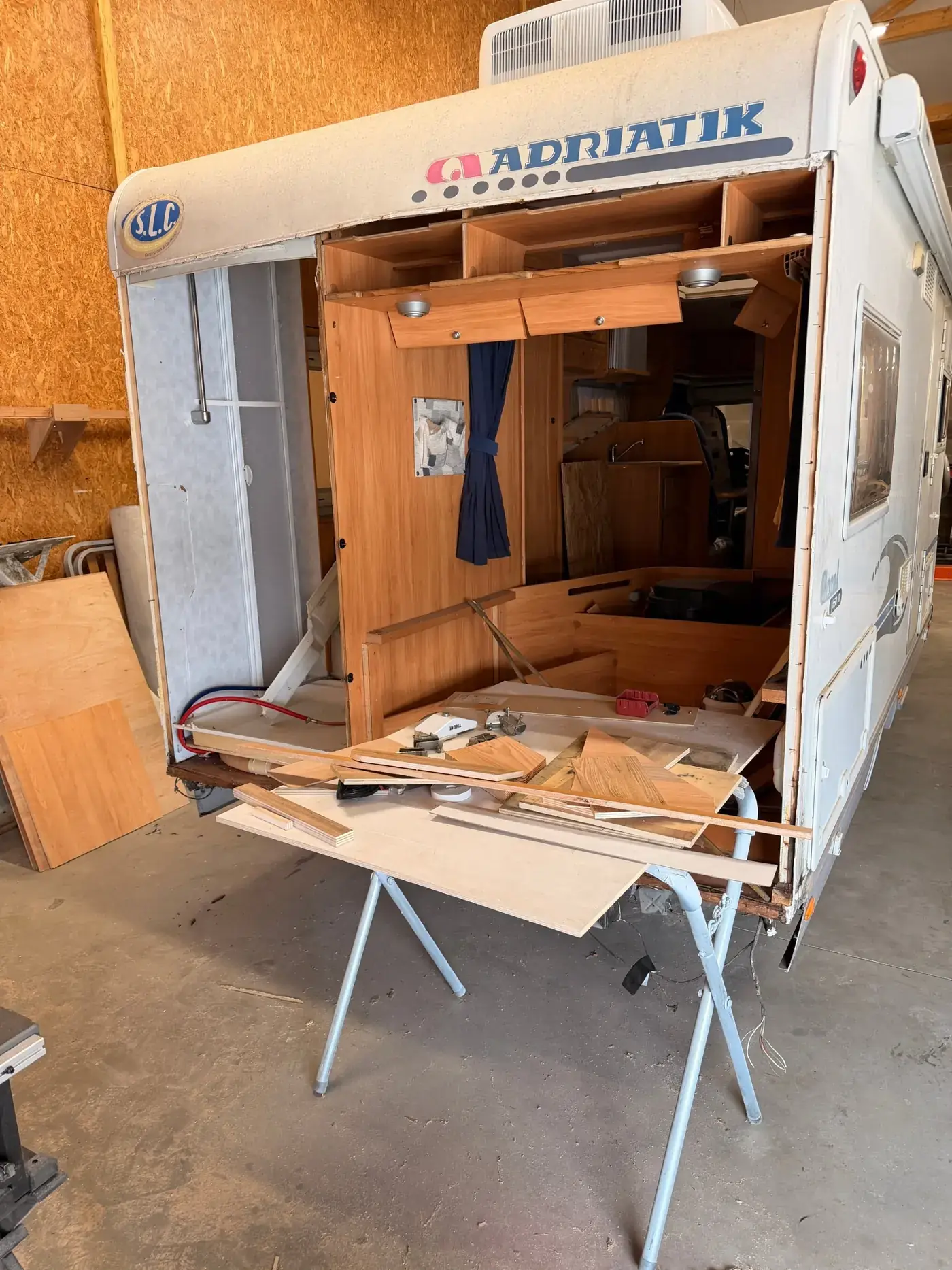 Arrière d'un camping-car ouvert à l'atelier, aménagement en cours de reconstruction