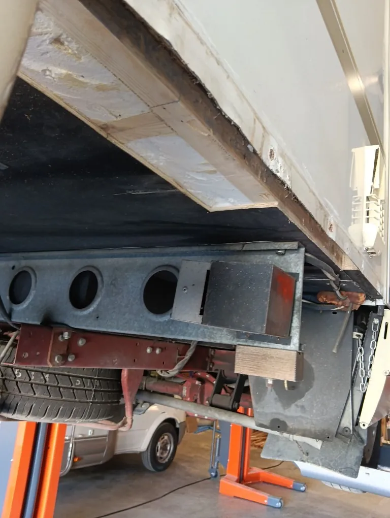 Soubassement d'un véhicule sur pont élévateur, remis en état avec du bois neuf